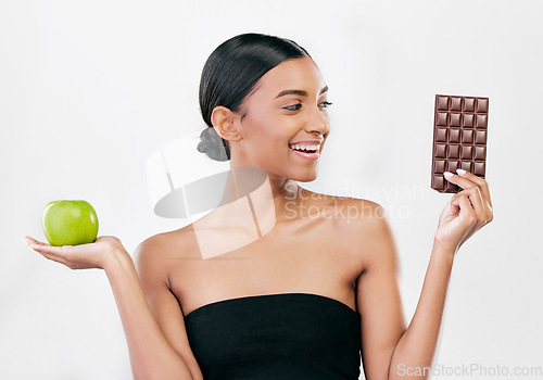 Image of Apple, chocolate and woman with healthy food choice or offer isolated on studio, white background for sugar and diet. Dessert, green fruit and young person with detox, vegan or lose weight decision