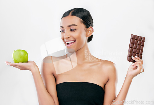 Image of Apple, chocolate and happy woman for healthy food choice, sugar and skincare isolated on studio, white background. Dessert, green fruit and african person detox, vegan beauty or dermatology decision