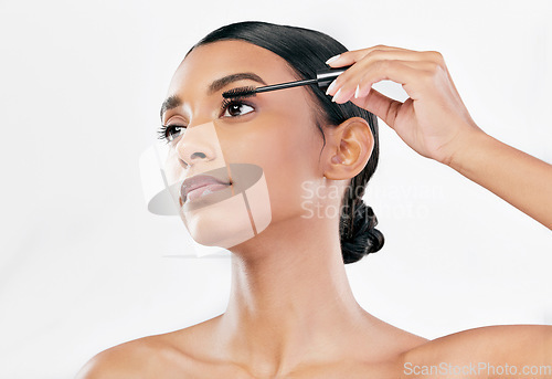 Image of Beauty, mascara and makeup of a woman with natural glow isolated on a white background. Eyelash, cosmetics and lash brush of Indian female model for facial shine, application and self care in studio