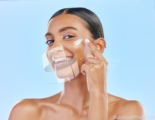 Image of Face, cream and beauty, woman in portrait with skincare and cosmetics product isolated on blue background. Lotion, sunscreen and facial mask, smile and moisturizer with female model and dermatology