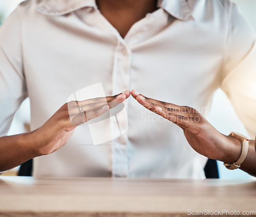 Image of Hand gesture, insurance and a black woman broker at a desk in her office for home loan, mortgage or cover. Hands, security and safety with a female agent sitting in the workplace for a surety offer