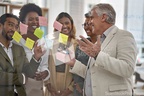 Image of Meeting, planning and glass with a senior man leading a presentation in a boardroom for company strategy. Teamwork, presentation and sticky notes in an office with a male manager talking to staff