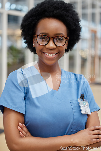 Image of Portrait, nurse and black woman with arms crossed, smile or happy in hospital. African medical professional, confidence and face of surgeon from Nigeria with glasses for healthcare service in clinic.