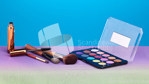 Image of Makeup, product and palette for color in studio, brush and cosmetics for beauty, mock up and blue background. Powder, mascara and skincare with transformation, change and eyeshadow for aesthetic