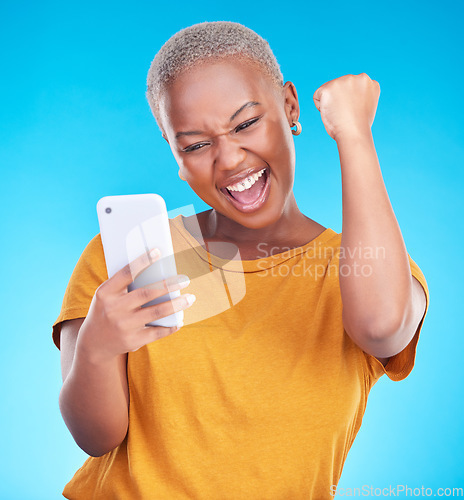 Image of Surprise, phone and happy black woman excited for announcement, winner notification or good news, alert or promo. Winning, cellphone info and studio person shocked, cheers or wow on blue background
