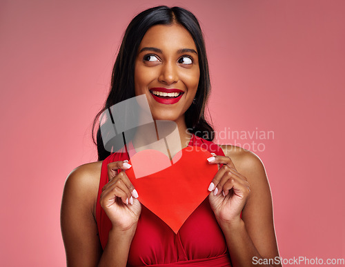 Image of Thinking, heart and valentines day with a woman on a pink background in studio for love or romance. Idea, red emoji and social media with an excited young female holding a shape or symbol of care