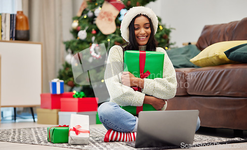 Image of Woman, Christmas present and laptop, video call and celebrate holiday, happiness and communication. Virtual conversation, contact on pc and female person at home with gift giving, package and smile