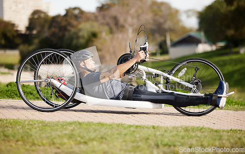 Image of Cycling, fitness and cardio with man and handcycle in nature for training, sports and challenge. Exercise, workout and marathon with person with a disability in park for wellness and health on road