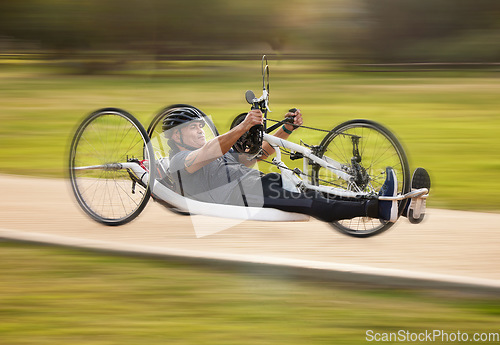 Image of Cycling, fitness and fast with man and handcycle in nature for training, sports and challenge. Exercise, workout and motion blur with person with a disability in park for cardio and health on road