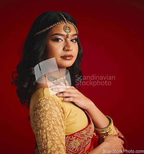 Image of Fashion, culture and portrait of Indian woman with beauty in traditional clothes, jewellery and sari. Religion, Hindu and face of female person on red background with accessory, cosmetics and makeup