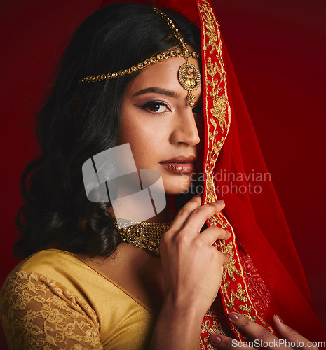 Image of Fashion, beauty and portrait of Indian woman with veil in traditional clothes, jewellery and sari. Religion, culture and eyes of female person on red background with accessory, cosmetics and makeup