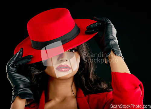 Image of Fashion, woman and glamour in portrait with red hat or makeup in india with studio background. Elegant female, hidden and face with style with beauty or cosmetics with designer outfit and classy.