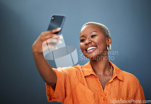 Image of Selfie, smile and black woman in studio for photography, video call or photo on grey background. Smartphone, happy and lady social media influencer with profile picture, live streaming or blog update