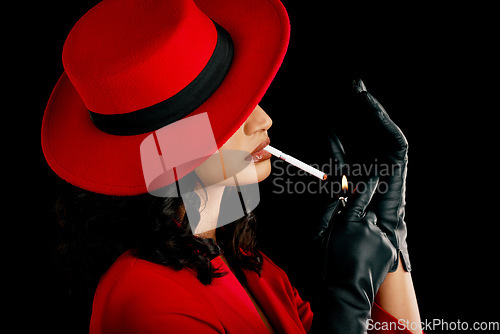 Image of Vintage, style and a woman smoking a cigarette with retro fashion, style and aesthetic. 90s, mystery and a model or mafia girl with a smoke and fashionable isolated on a black background in a studio