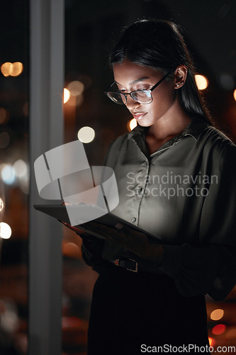 Image of Night, work or woman reading on tablet for research, project or planning a proposal in office building, startup or professional employee. Overtime, working or search on internet, online communication