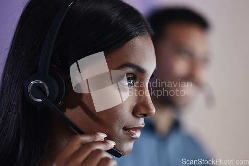 Image of Woman, call center and headphones at night in customer service, support or telemarketing at the office. Face of serious female person, consultant or agent with headset for online advice or assistance