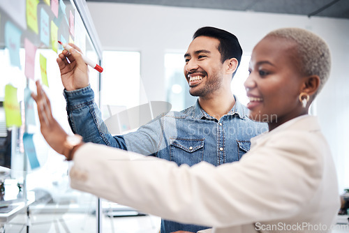 Image of Happy creative people, writing and glass board for schedule planning, strategy or brainstorming at office. Man and woman in teamwork for startup project plan, sticky note or tasks at the workplace