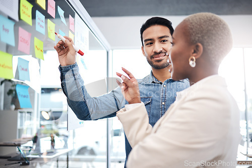 Image of Creative people, writing and meeting on glass board for schedule planning, strategy or brainstorming at office. Man and woman in teamwork for startup project plan, sticky note or tasks at workplace