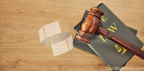 Image of Gavel, law and books on wooden table, space or mockup for judge, justice or lawyer in courtroom. Background, hammer and research knowledge for legal study, constitution and truth, litigation or trial