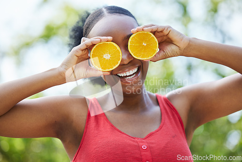 Image of Happy black woman, vitamin C and orange on eyes for natural nutrition or citrus diet in nature outdoors. Portrait of African female person smile with organic fruit for health and wellness in the park