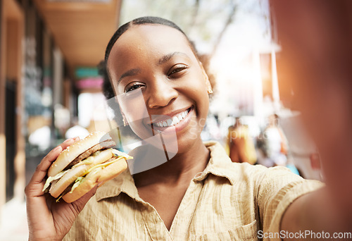 Image of Burger, portrait and woman in selfie, city and restaurant outdoor promotion, social media and live streaming review. Fast food, happy face and african person or influencer on sidewalk for photography