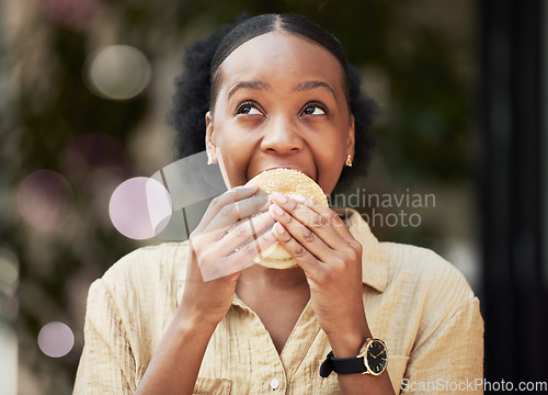 Image of Thinking, fast food and black woman biting a burger in an outdoor restaurant as a lunch meal craving deal. Breakfast, sandwich and young female person or customer enjoying a tasty unhealthy snack