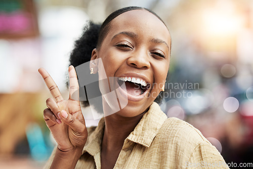 Image of Portrait, smile and peace with an excited black woman on a blurred background posing for a photograph. Face, emoji and profile picture with a happy young female comic looking playful while laughing