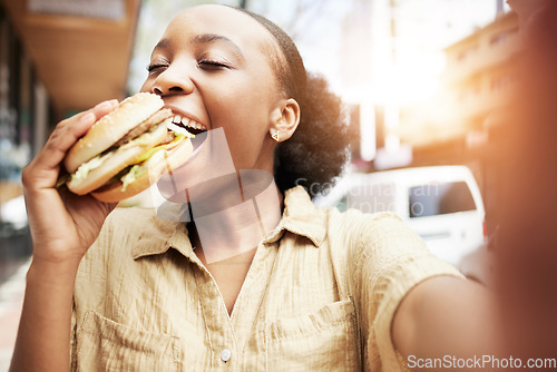 Image of Burger, eating and black woman in selfie, city and restaurant for outdoor promotion, social media and live streaming review. Fast food, hungry customer, person or influencer with lunch or photography