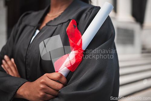 Image of University, graduation and certificate with a student arms crossed on campus, confident in her achievement. Diploma, education and college with an african graduate standing outdoor at a ceremony