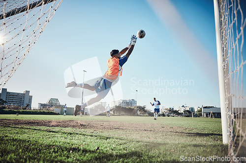 Image of Fitness, goalkeeper or soccer player taking a penalty in a game or training match at a tournament. Save, back or male football athlete kicking ball at practice on outdoor field or pitch in stadium