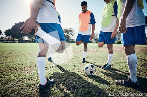 Image of Stretching legs, football player and men training on a field for sports game and fitness. Male soccer team or athlete group together for challenge, workout or exercise outdoor on a grass pitch