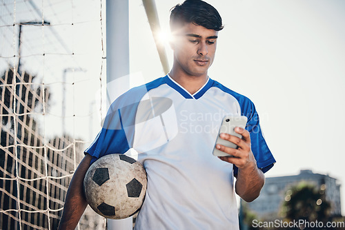 Image of Soccer ball, phone and man on field for competition, training or fitness news, social media chat and blog. Football player or person search on mobile app for sports information, health or goals check