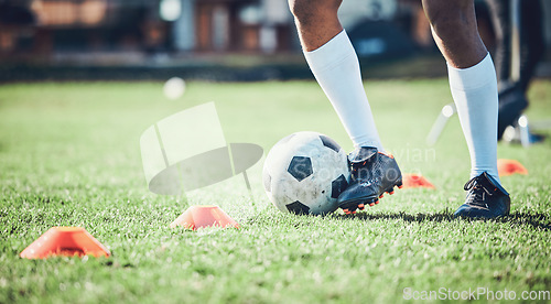 Image of Soccer player, feet and ball with training cone on a field for sports game and fitness. Legs or shoes of male football or athlete person outdoor for agility exercise, performance or workout on grass