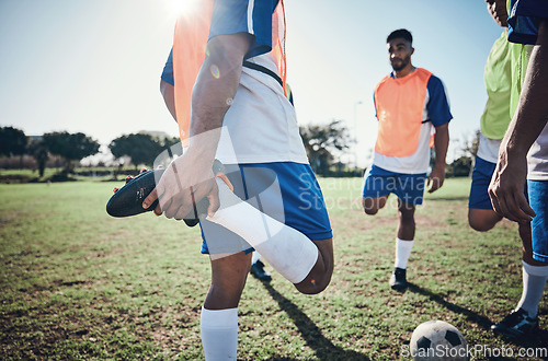 Image of Football player, stretching legs and men training on a field for sports game and fitness. Male soccer team or athlete group outdoor for challenge, workout or warm up exercise on a grass pitch