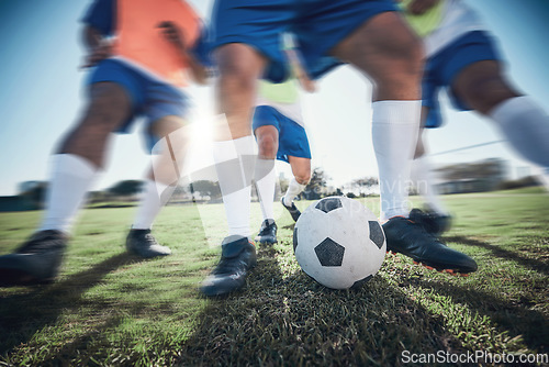 Image of Football player, feet and men with a ball together on a field for sports game or fitness. Blurred closeup of male soccer team or athlete group for tackle challenge, action or training workout outdoor