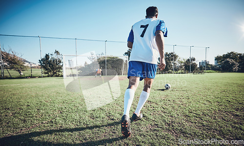 Image of Sports, penalty and soccer player score a goal at training, game or match at a tournament. Fitness, exercise and back of a male football athlete kicking a ball at practice on outdoor field at stadium