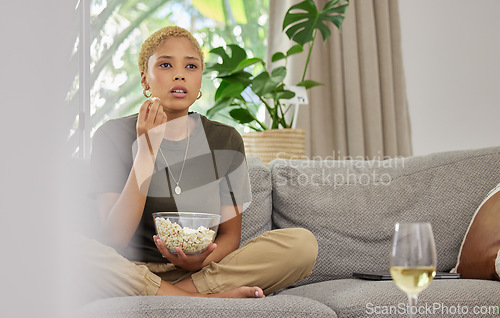 Image of Woman, popcorn and watch a movie, streaming online with service and relax at home on sofa. Female person, subscription and internet, watching drama film or series with cinema snack and television