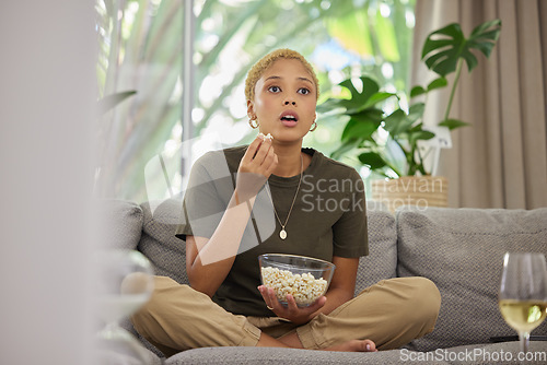 Image of Surprise, watching tv and a woman on the sofa with popcorn for a movie or show. Wow, house and a young girl eating a snack while on the living room couch for a horror, film or streaming a drama