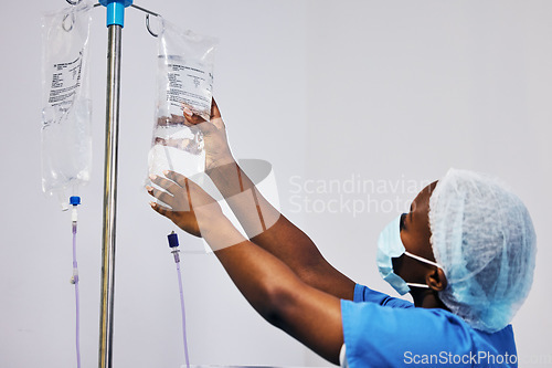Image of Hospital, nurse with face mask and black woman with iv drip medicine, fluid infusion or liquid injection bag. Nursing, doctor or surgeon monitoring intravenous medication, .anesthesia or healthcare