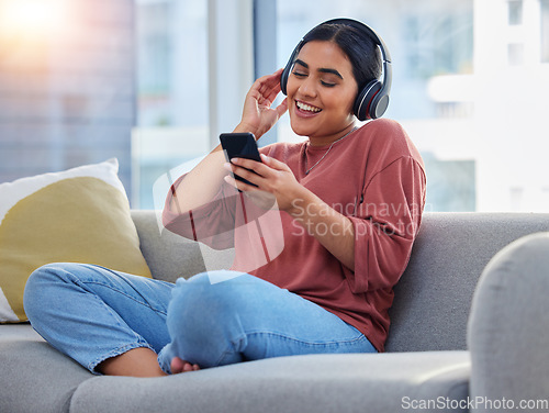 Image of Relax, music and phone with woman on sofa and dance for streaming, social media and audio. Happy, technology and radio with person listening to headphones in living room at home for energy and sound