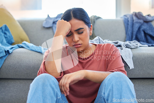 Image of Headache, depression and woman with stress from laundry in a living room, exhausted and unhappy in her home. Anxiety, migraine and female person overwhelmed with household, task or spring cleaning
