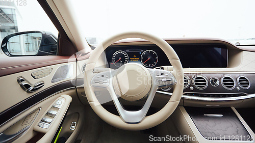 Image of Car interior luxury. Interior of prestige modern car. Leather comfortable seats, dashboard and steering wheel. White cockpit with exclusive wood and metal decoration