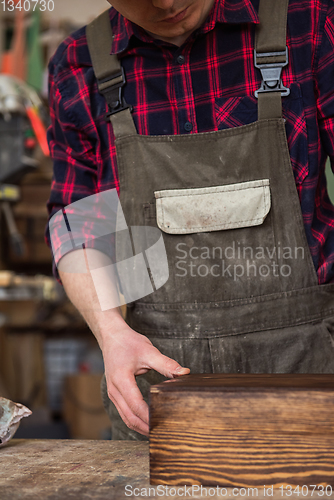 Image of Carpenter painting wooden