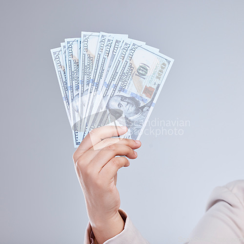 Image of Money, hand and woman in studio with savings, success or cashback, reward and bonus on grey background. Cash, investment and female winner show casino, poker or gambling award with financial freedom