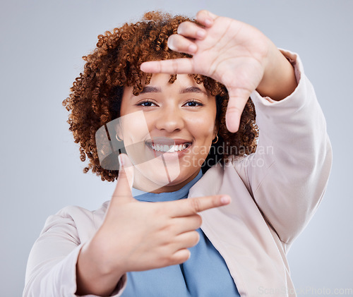 Image of Hand, frame and happy woman portrait in studio with sign for photo, photography or fun picture on grey background. Face, lady and beauty influencer with emoji finger for social media or selfie smile