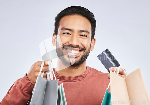 Image of Shopping bag, portrait and man with happiness, credit card and smile for retail fashion spree, sales or Black Friday deal. Promotion face, studio payment and happy male customer on white background