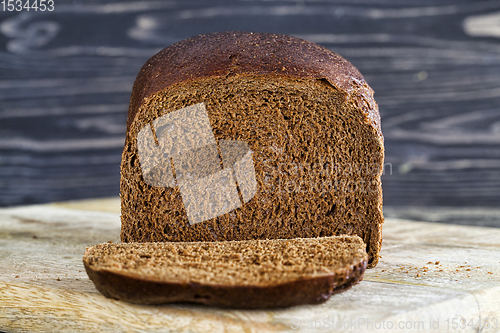 Image of bread sliced on wooden cutting Board