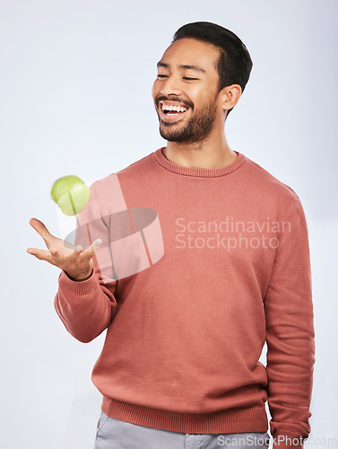 Image of Studio, fruit throw and happy man with apple product for self care diet, clean healthy gut or nutrition meal, vitamin or detox. Happiness, nutritionist food or hungry person smile on white background