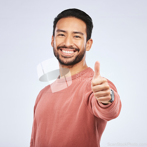 Image of Thumbs up, portrait and happy asian man in studio, white background and thank you. Male model, thumb emoji and smile of winner, achievement and celebration of feedback, good review and yes with hands