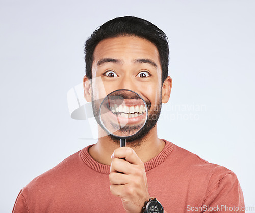 Image of Magnifying glass, mouth and portrait of a man with a smile for teeth, beauty or dental hygiene. Happy, healthy and an Asian person or model with gear to show oral care results on a white background